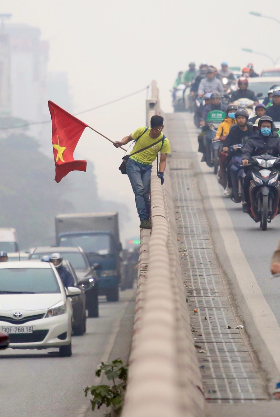 Người đàn ông nghi "ngáo đá" leo trèo trên lan can cầu Ngã tư Vọng.