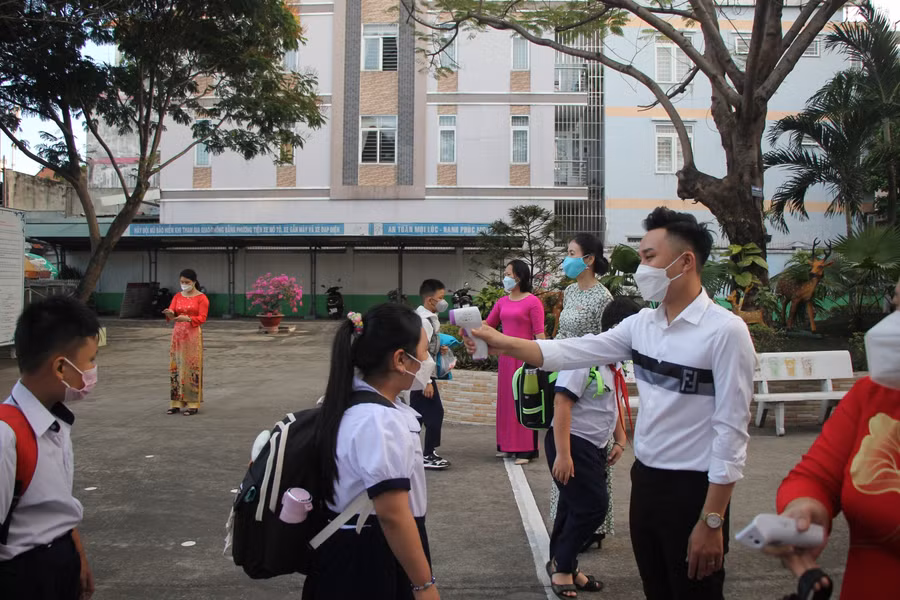 Học sinh Tiểu học được đo thân nhiệt trước khi vào trường.