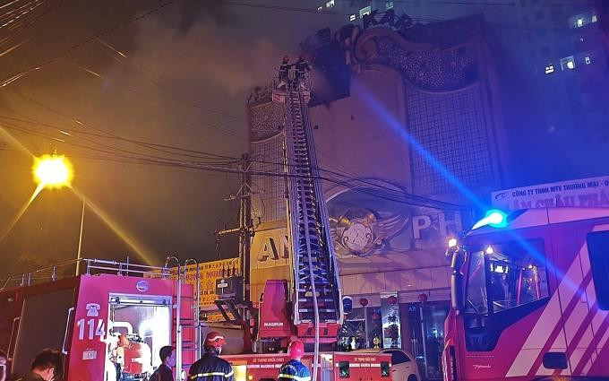 Cảnh sát dùng xe thang dập lửa cháy ở phía trước quán karaoke đêm 6/9.
