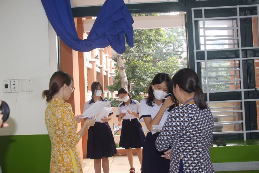 Cán bộ coi thi tại điểm thi Trường THPT Nguyễn Hữu Huân gọi thí sinh vào phòng.