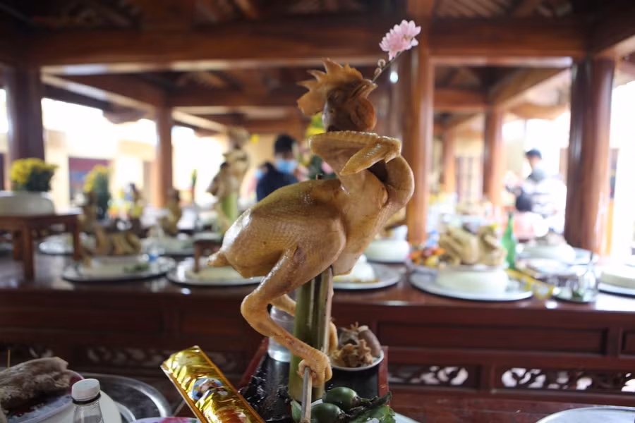 Một thế gà ngồi được bày biện trên mâm cỗ. Gà sau khi làm thịt sẽ được "gia cố" bằng tre, lạt, dây thép... để tạo thế. Theo kinh nghiệm của người dân, thế gà quỳ, ngồi phải quấn lá chuối quanh cổ. Luộc chín sẽ bật quạt và ấn nắn tạo thế để khi nguội có con gà thế đẹp nhất.