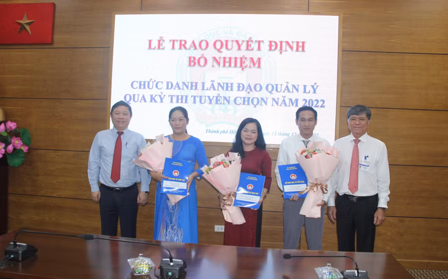 Ông Dương Anh Đức (ngoài cùng bên trái) và ông Nguyễn Văn Hiếu tặng hoa chúc mừng và trao quyết định bổ nhiệm các phó hiệu trưởng.