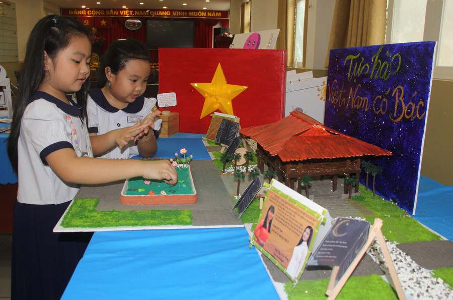 Học sinh Trường tiểu học Nguyễn Bỉnh Khiêm thích thú với mô hình nhà sàn “Tự hào Việt Nam có Bác”.