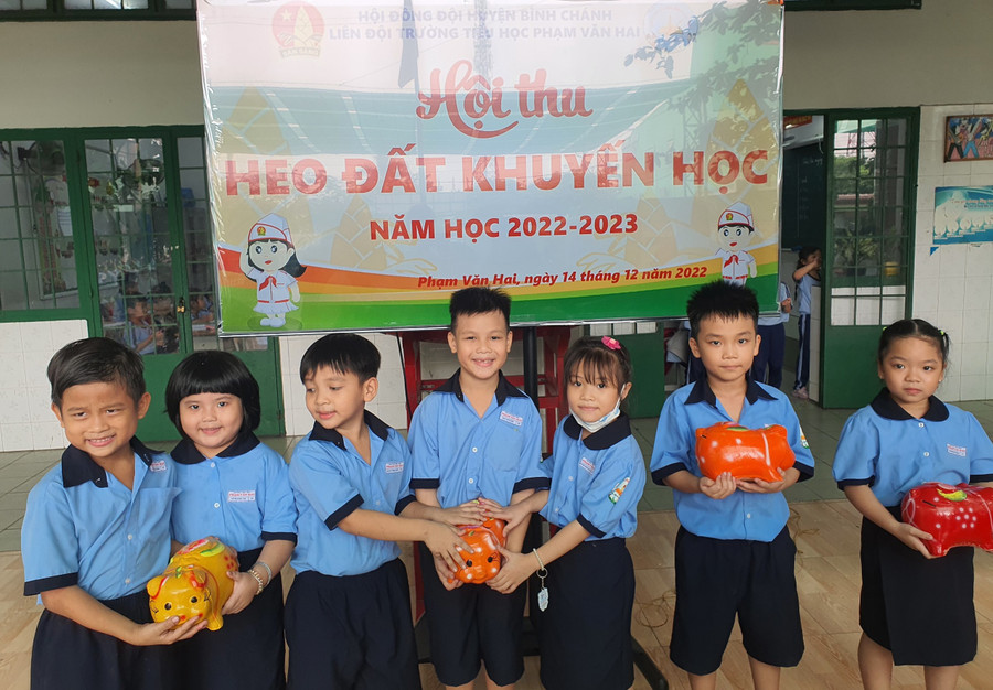 Học sinh Trường tiểu học Phạm Văn Hai thu heo đất giúp đỡ bạn nghèo.