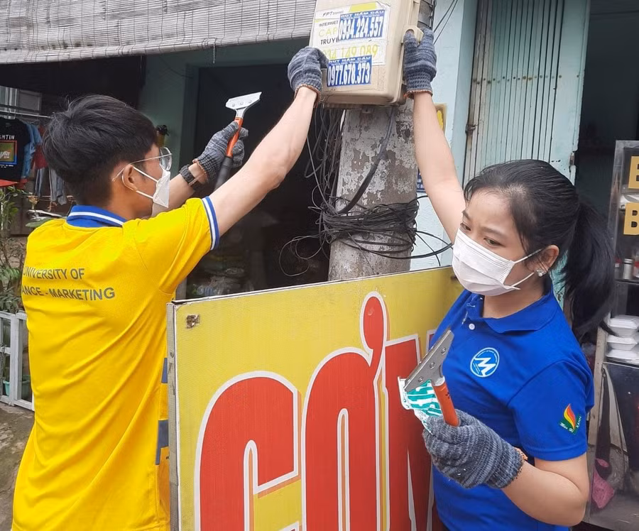 Vào sáng chủ nhật hàng tuần, sinh viên Trường ĐH Tài chính-Marketing bóc gỡ quảng cáo tín dụng đen nơi công cộng.