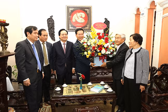 Trưởng ban Tuyên giáo TW Võ Văn Thưởng và Bộ trưởng Phùng Xuân Nhạ tặng hoa chúc mừng GS Phạm Minh Hạc tại nhà riêng.