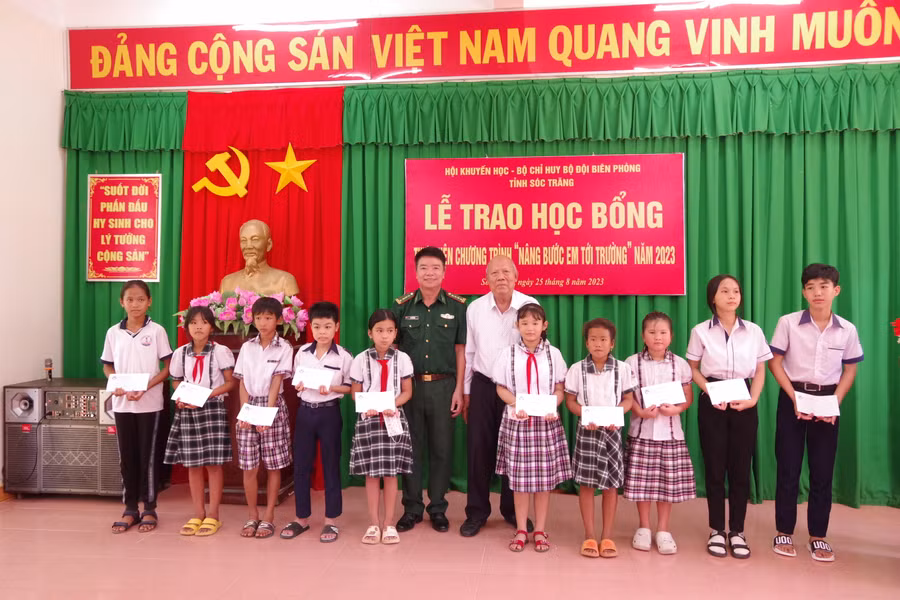 Đại diện lãnh đạo BĐBP tỉnh và Hội khuyến học tỉnh trao học bổng cho các em học sinh.