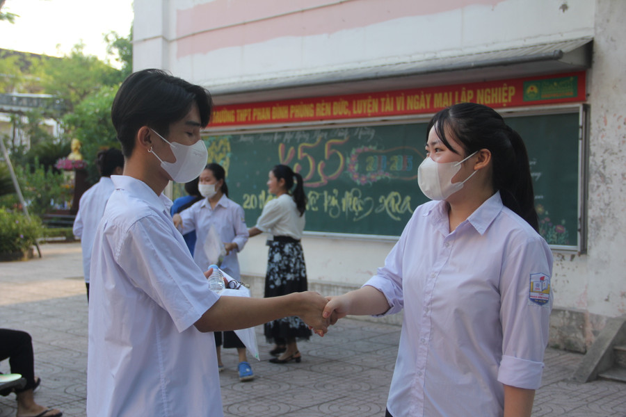 Đôi bạn bắt tay chúc nhau đạt điểm cao trước buổi thi đầu tiên.