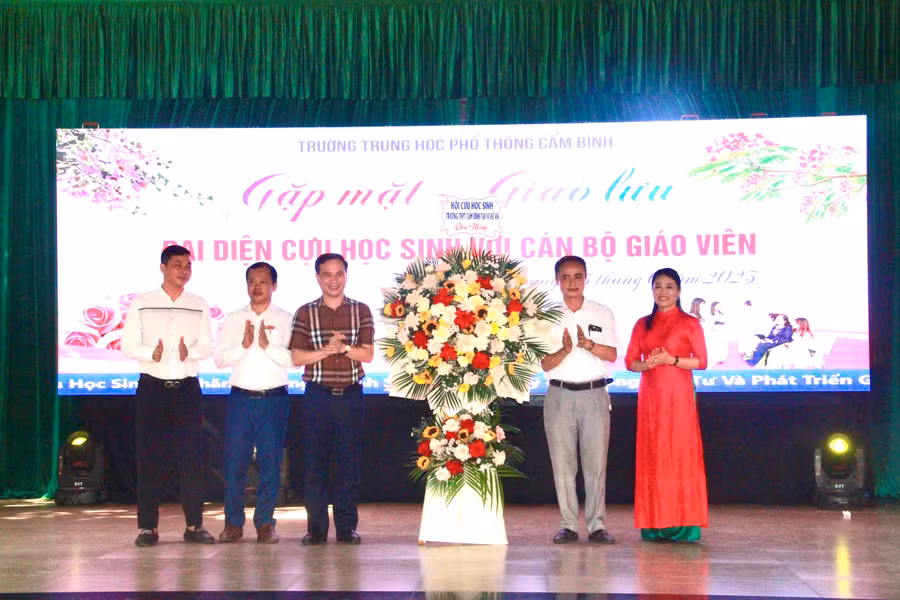 Đại diện cựu học sinh tặng hoa chúc mừng 5 năm thành lập Quỹ học bổng trường THPT Cẩm Bình.