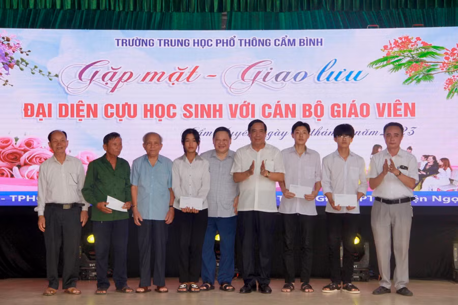 Đại diện Quỹ học bổng Đầu tư và phát triển trường THPT Cẩm Bình trao quà cho học sinh khó khăn.
