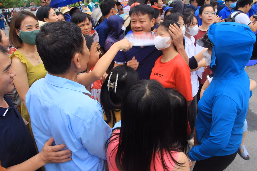 Phụ huynh động viên con sau 150 phút làm bài.