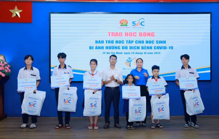 Học sinh bị ảnh hưởng bởi dịch bệnh Covid-19 nhận học bổng bảo trợ. Ảnh Minh Sang.