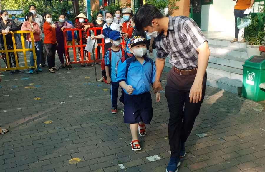 Giáo viên Trường Tiểu học Phạm Văn Hai (Bình Chánh) đón học sinh vào lớp.