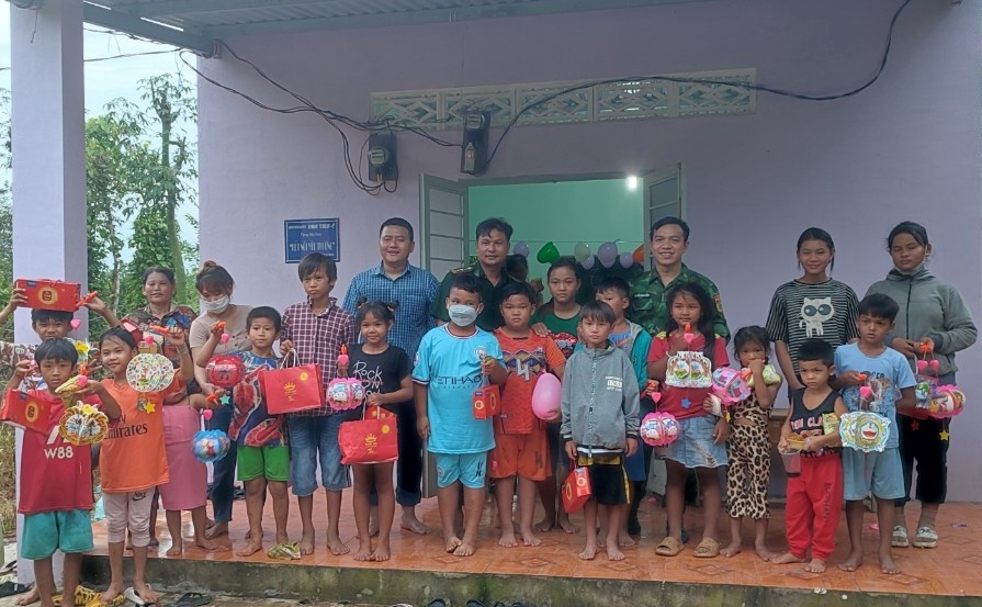 Lực lượng Biên phòng vận động các mạnh thường quân tặng quà cho trẻ tại lớp học xóa mù chữ.