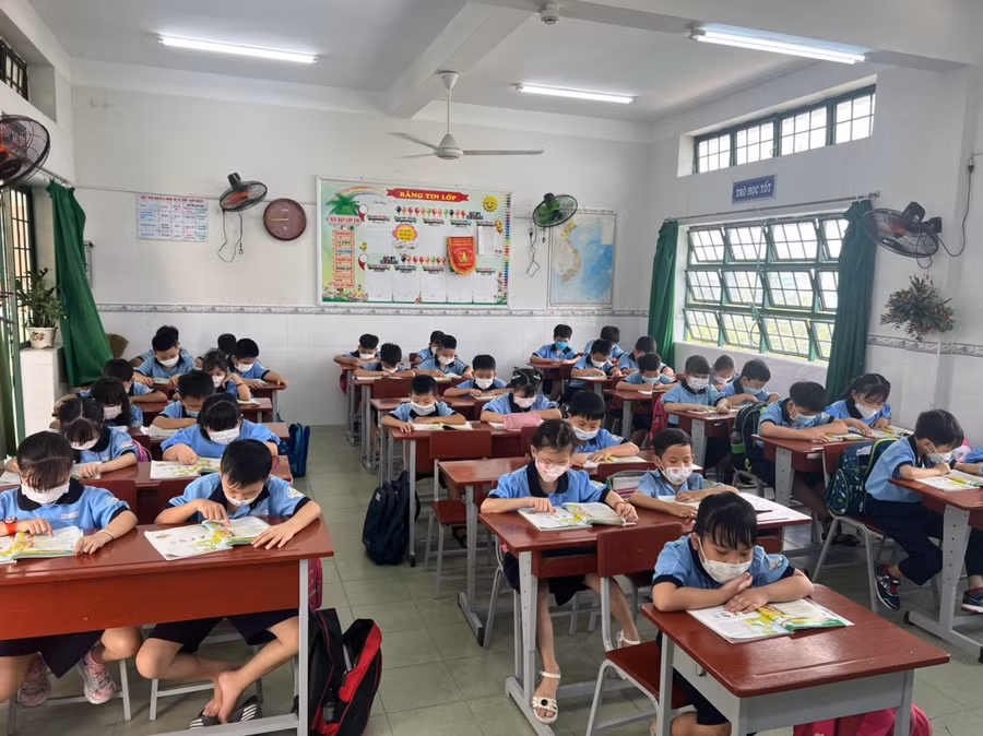 Học sinh Trường tiểu học Phạm Văn Hai (Bình Chánh, Thành phố Hồ Chí Minh) đảm bảo việc đeo khẩu trang trong giờ học.