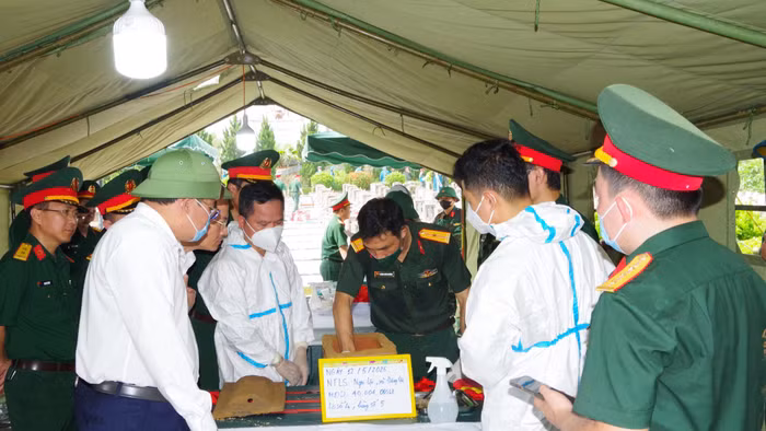 Lực lượng chức năng lấy mẫu sinh phẩm hài cốt liệt sĩ tại Nghĩa trang liệt sĩ Nghi Lộc.