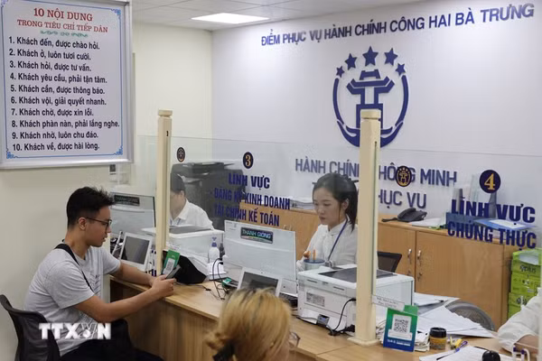 Người dân được cán bộ, công chức hỗ trợ giải quyết hồ sơ tại Điểm phục vụ Hành chính công phường Hai Bà Trưng (Hà Nội). (Ảnh: Vũ Quang/TTXVN).