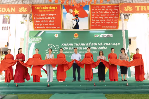 Các đại biểu cắt băng khánh thành bể bơi tại sự kiện.