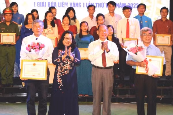 Thầy Cao Xuân Lương (trái) nhận giải thưởng Cuộc thi sáng tác học tập và làm theo Bác Hồ. Ảnh: TG.