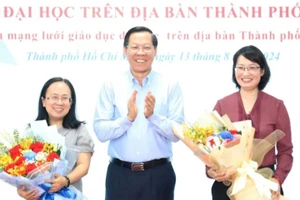 Chủ tịch UBND TPHCM Phan Văn Mãi trao hoa chúc mừng bà Trần Thị Diệu Thúy (bên phải) và bà Đinh Thị Thanh Thủy. Ảnh: T.Thuyền