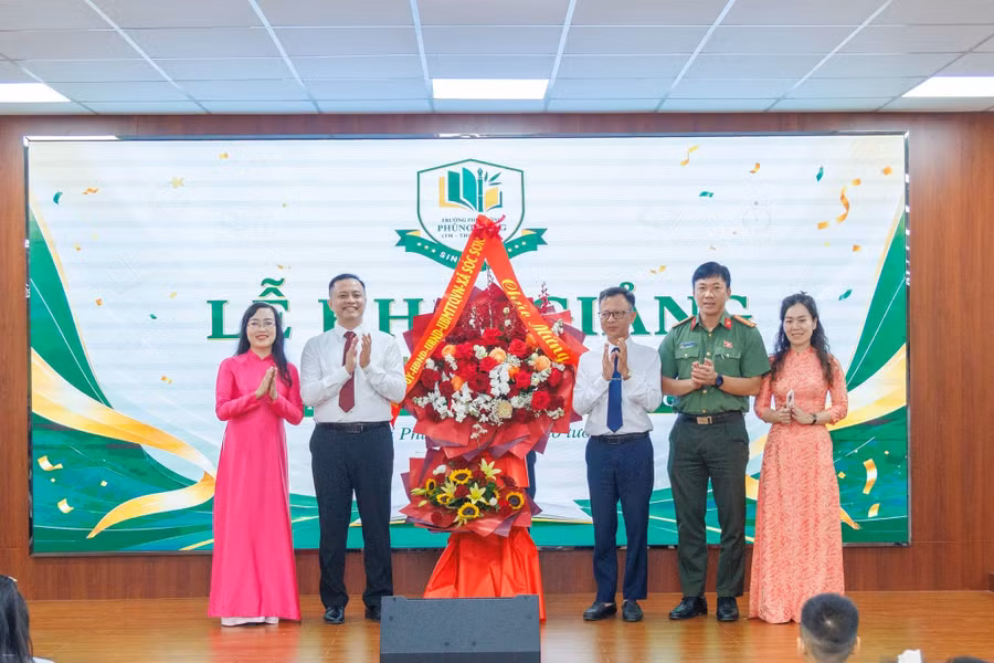Đại diện Đảng ủy - UBND xã Sóc Sơn và các đoàn thể địa phương tặng hoa chúc mừng nhà trường.
