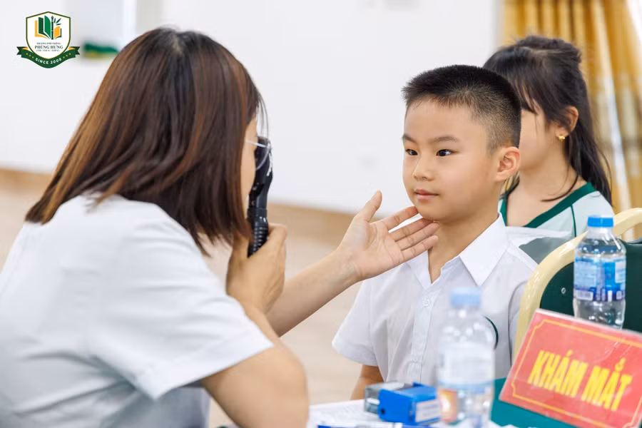 Nhân viên y tế khám mắt cho học sinh Trường Phổ thông Phùng Hưng.