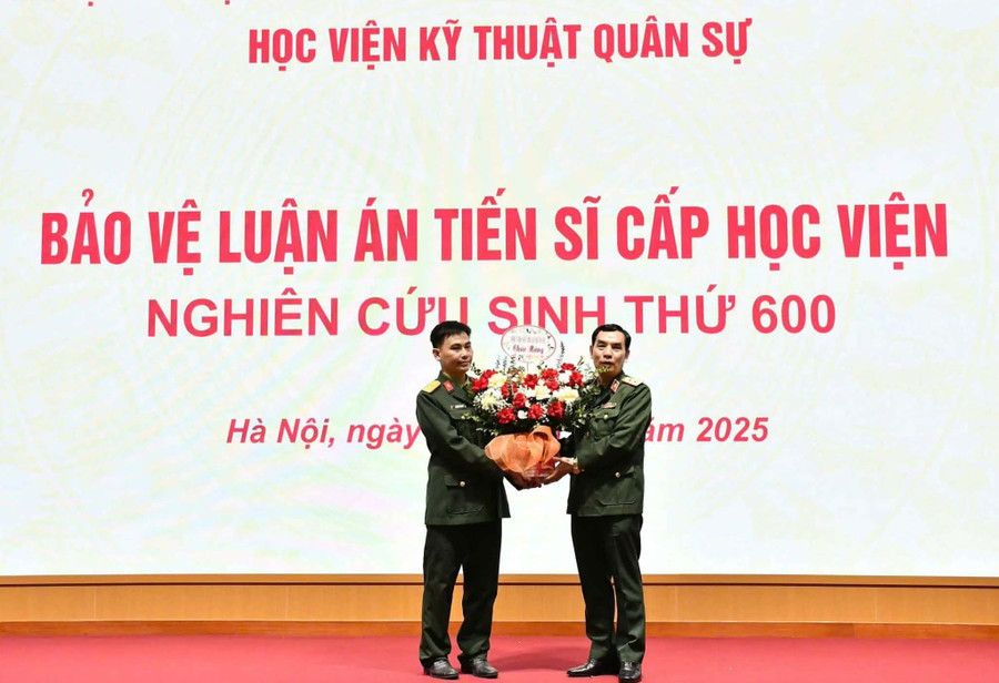 Trung tướng Lê Minh Thái – Giám đốc Học viện Kỹ thuật quân sự tặng hoa chúc mừng Nghiên cứu sinh Nguyễn Văn Hường bảo vệ luận án tiến sĩ thành công.