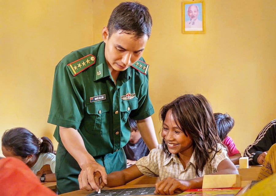 Thiếu tá Nguyễn Văn Luân dạy cho bà con làng Khôn biết đọc, biết viết. Ảnh: Internet. xoamuchujpg1.jpg