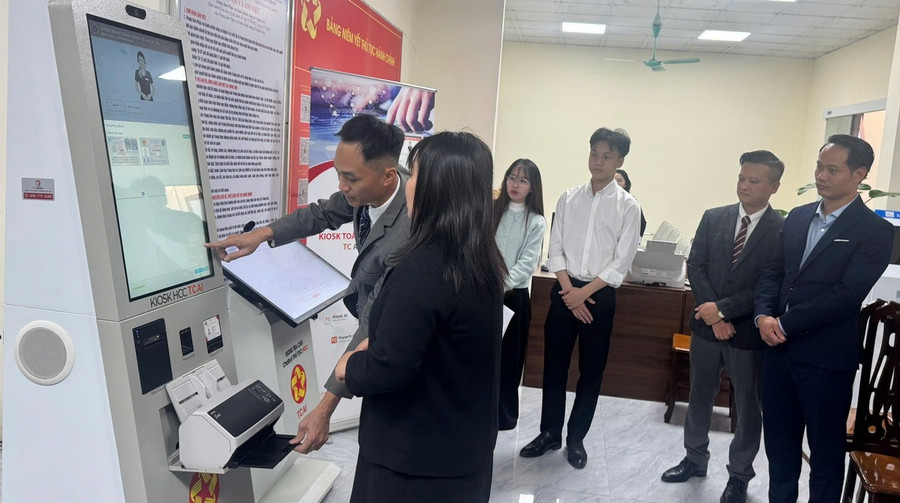 Đại diện đơn vị tài trợ và lãnh đạo UBND xã Nghĩa Trụ quan sát và hỗ trợ người dân đến trải nghiệm robot trong ngày 30/12. Ảnh: T.Đảng