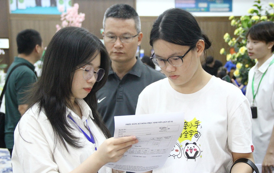 Sinh viên khóa trước hướng dẫn tân sinh viên một số thông tin cần điền vào giấy tờ, hồ sơ nhập học. img-2743.jpg