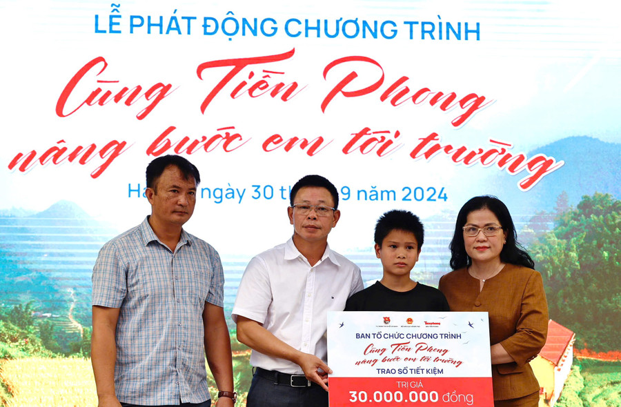 Thứ trưởng Nguyễn Thị Kim Chi và nhà báo Phùng Công Sưởng trao sổ tiết kiệm cho học sinh làng Nủ.