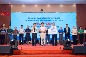 Ông Phạm Tuyên, Giám đốc chi nhánh Vinamilk Hà Nội (đứng giữa) trao bảng tượng trưng món quà 41.000 hộp sữa cho trẻ em Phú Thọ.