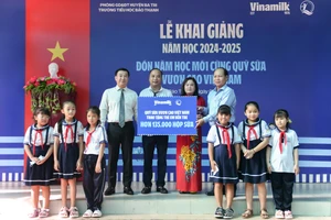 : Đại diện Vinamilk & Quỹ bảo trợ trẻ em Việt Nam (bên trái) trao bảng tượng trưng phần hỗ trợ hơn 135.000 hộp sữa cho đại diện Sở Lao động thương binh & xã hội tỉnh Bến Tre nhân ngày khai giảng 5/9