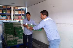 Nhân viên Vinamilk khẩn trương chuẩn bị, bốc xếp sữa tươi, nước uống chuyển lên xe để đưa đến cho người dân, trẻ em tại vùng bão lũ.