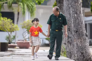 Thượng sĩ Nguyễn Chí Tường cùng con một nhân viên Vinamilk tại Trung tâm Điều dưỡng Thương binh và Người có công Long Đất (Ảnh: Thanh Bình).