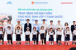 Các đại biểu trao tặng mũ bảo hiểm cho các em học sinh lớp 1 trường Tiểu học Tiểu La (quận Sơn Trà).