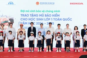 Các đại biểu trao tặng mũ bảo hiểm cho các em học sinh lớp 1 trường Tiểu học Tiểu La (quận Sơn Trà).