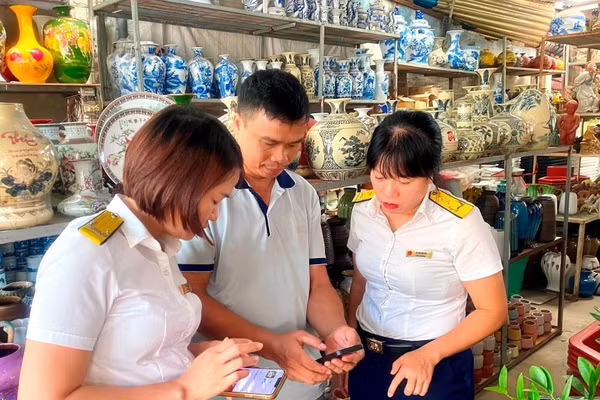 Cán bộ thuế thành phố Hải Phòng hỗ trợ trực tiếp người dân, hộ kinh doanh cài đặt ứng dụng thuế điện tử eTax Mobile. Ảnh minh họa: INT