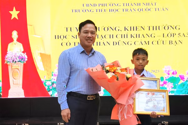 Ông Lưu Tiến Quang - Phó Giám đốc Sở GD&ĐT Đắk Lắk trao Thư, Giấy khen của Giám đốc Sở cho em Thạch Chí Khang. (Ảnh: TT)