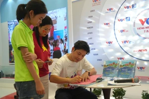 Nhạc sĩ Nguyễn Văn Chung ký tặng sách cho độc giả.