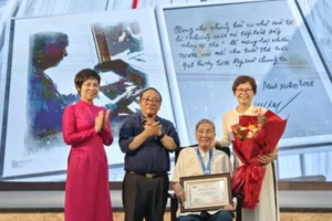 Nhà báo Vũ Việt Trang, Tổng giám đốc TTXVN và nhà thơ Trần Đăng Khoa, Phó Chủ tịch Hội Nhà văn Việt Nam, Chủ tịch Hội đồng giám khảo trao Giải Hiệp sĩ Dế Mèn cho nhạc sĩ Phạm Tuyên. Ảnh: Huy Thông.