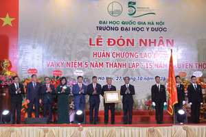 Bộ trưởng Bộ GD&ĐT Nguyễn Kim Sơn thừa ủy quyền của Chủ tịch nước trao Huân chương Lao động hạng Ba cho Trường Đại học Y Dược-Đại học Quốc gia Hà Nội.