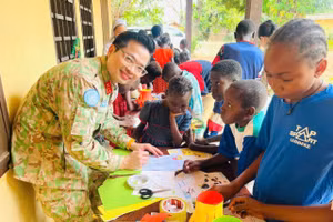 Trung tá Duy Văn Sơn, Tổ trưởng Tổ công tác Bộ Quốc phòng Việt Nam tại Phái bộ MINUSCA hướng dẫn các em nhỏ Trung Phi làm đèn lồng.