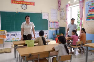 Cô giáo Lục Thị Lương, Hiệu trưởng Trường PTDTBT Tiểu học Cốc Pàng trao đổi với học sinh Điểm trường Chè Lếch. Ảnh: Quốc Tuân - Phạm Vũ.