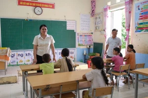 Cô giáo Lục Thị Lương, Hiệu trưởng Trường PTDTBT Tiểu học Cốc Pàng trao đổi với học sinh Điểm trường Chè Lếch. Ảnh: Quốc Tuân - Phạm Vũ.