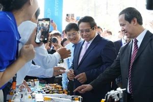 Thủ tướng Phạm Minh Chính và Bộ trưởng Bộ GD&ĐT Nguyễn Kim Sơn tham quan các gian hàng trưng bày sản phẩm tại Ngày hội Khởi nghiệp quốc gia của HSSV. Ảnh: HCMUTE 