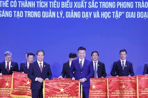 Nhà báo Triệu Ngọc Lâm - Tổng Biên tập Báo Giáo dục và Thời đại thay mặt tập thể Báo nhận Cờ thi đua từ Bộ trưởng Nguyễn Kim Sơn. Ảnh: Lê Cường.