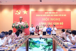 Bộ trưởng Bộ GD&ĐT Nguyễn Kim Sơn và đại diện Đoàn đại biểu Quốc hội thành phố Hà Nội tặng hoa chúc mừng bà Bùi Thị Minh Hoài. 