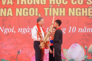 Các em học sinh xã Na Ngoi tặng Tổng Bí thư Tô Lâm khèn và khăn Piêu, nét bản sắc của đồng bào dân tộc thiểu số trên địa bàn. Ảnh: Hồ Lài