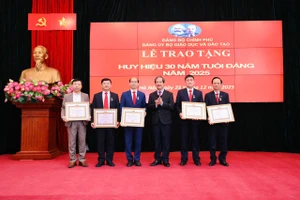 Bí thư Đảng ủy, Bộ trưởng Nguyễn Kim Sơn trao Huy hiệu 30 năm tuổi Đảng cho các đảng viên thuộc Đảng bộ Bộ GD&ĐT. 